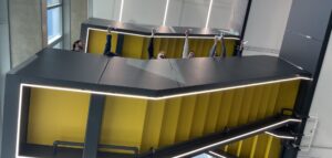 Hands dropping paper helicopters from a high level black and yellow staircase